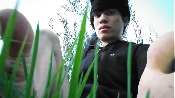Image Jon Arteen in short shorts walks on grass barefoot, shows his boy soles, smiles for you
