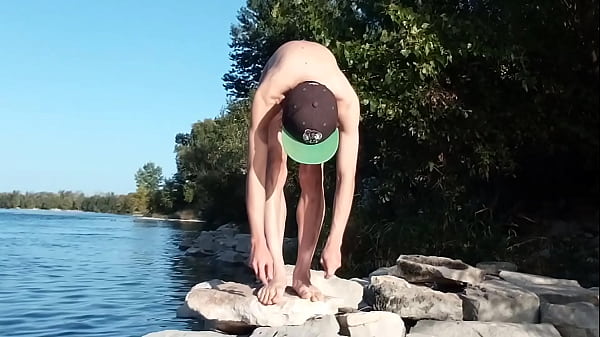 Image Gay twink does naked yoga outside on a rocky beach, gay cruising men passing by might watch him