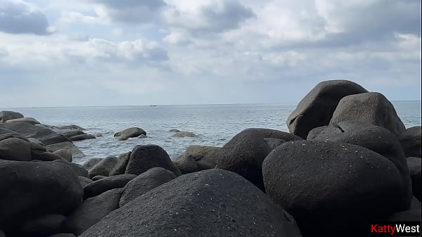 Image Naked brunette masturbates with oil on a public beach