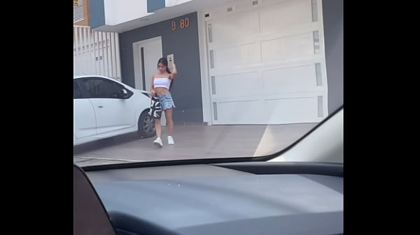 Image jovencita vaquera recibiendo palanca  en el carro de un conductor en zona publica