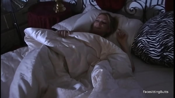 Image A sexy blonde bride gives the groom a footjob and gets cum on her face.