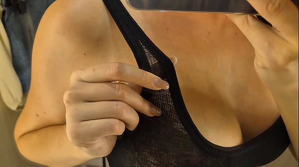 Image Trying on transparent clothes in the fitting room. Naked blonde flashed her boobs in a public place.