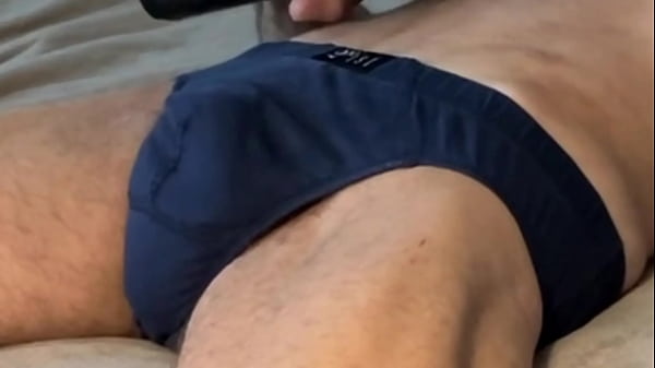 Image Writhing and Stretching in Bed in dark Briefs Underwear with 2 massage guns concentrating on Pelvic and Groin area