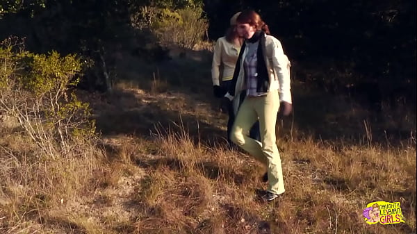 Image A couple of brunettes have some wild lesbian sex with a strapon on a hike