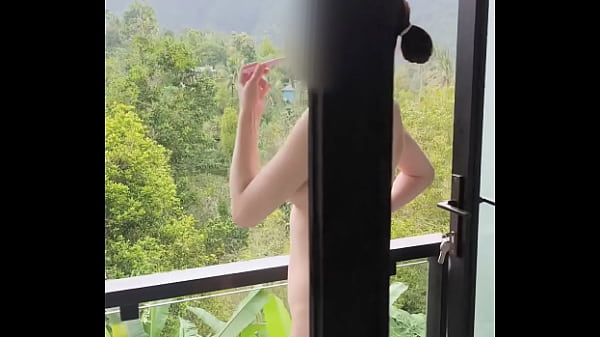Image Brushing teeth naked on a terrace with a full view of forest
